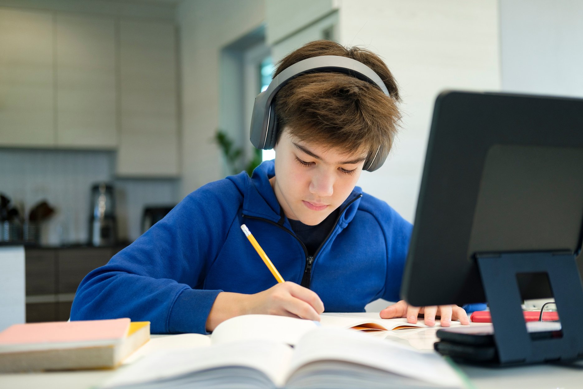 Student boy with tablet computer learning at home